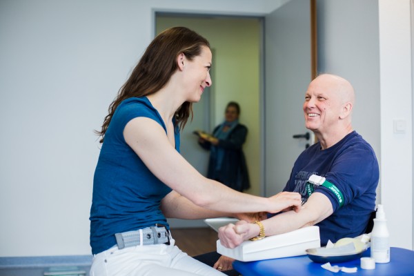 Mitarbeiterin mit Patient bei der Blutentnahme
